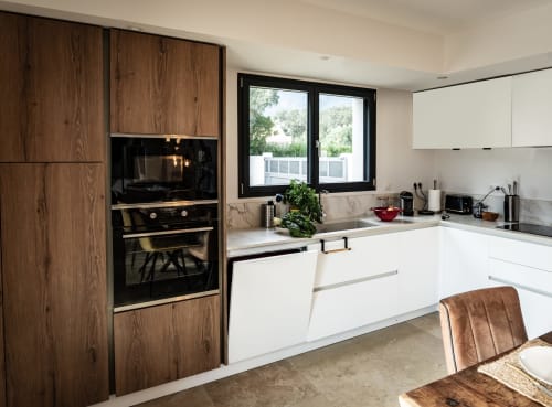 Cuisine moderne de la Villa LINETTE à La Conciergerie du Cap Corse, Centuri avec mobilier en bois, plan de travail blanc et vue montagne
