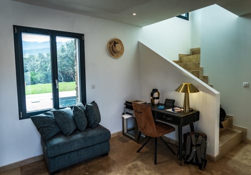 Espace de travail de villa moderne avec vue sur les montagnes, bureau, fauteuil turquoise et escalier à La Conciergerie du Cap Corse, Centuri