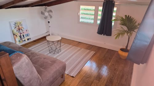 Chambre lumineuse avec parquet, mobilier confortable, ventilateur et plante à Villa Tourmaline au Lorrain