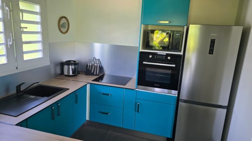 Cuisine turquoise moderne avec appareils en acier inoxydable, micro-ondes et réfrigérateur à la Villa Tourmaline au Lorrain
