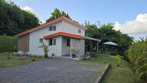 Villa Tourmaline, maison d'hôtes au Lorrain avec murs blancs, toiture orangée, vue sur jardin et paysagisme tropical