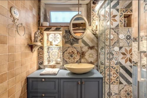 Bagno elegante nello Eleanor Secret Studio, Campo de Fiori con piastrelle decorative, lavabo a bacinella e specchio ornamentale