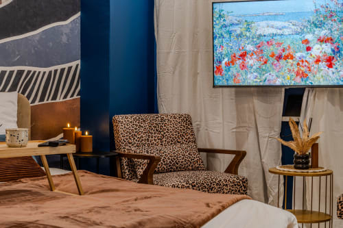 Stylish bedroom at Wellkhome Bordeaux with leopard chair, city view, flat-screen TV, candles, and modern décor