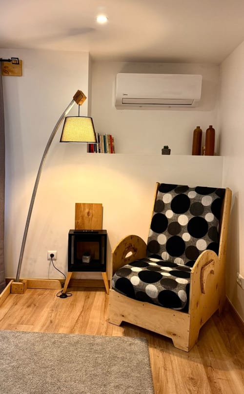 Quarto aconchegante da Kindnessmoon B&B em Óbidos com cama de madeira, luminária de arco e comodidades modernas, incluindo ar-condicionado e TV.