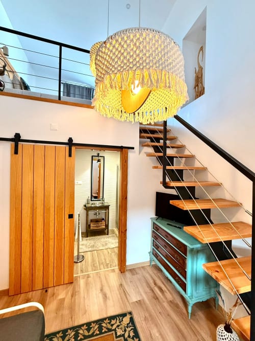 Quarto de loft moderno em Kindnessmoon, Óbidos, com luminária amarela, escada de madeira e porta de celeiro para banheiro