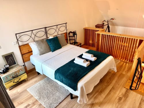 Quarto aconchegante na Kindnessmoon em Óbidos com cama de madeira, almofadas decorativas e vista para a cidade da varanda