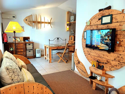 Cozy villa living room in Obidos with wooden fish decor, yellow lamp, TV, and rustic furnishings at Kindnessmoon