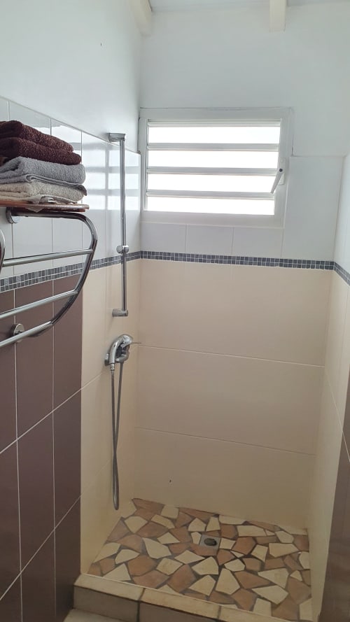 Salle de bain moderne avec carrelage crème et sol en mosaïque du gîte Le Nid De Bellemont, Trois-Rivières