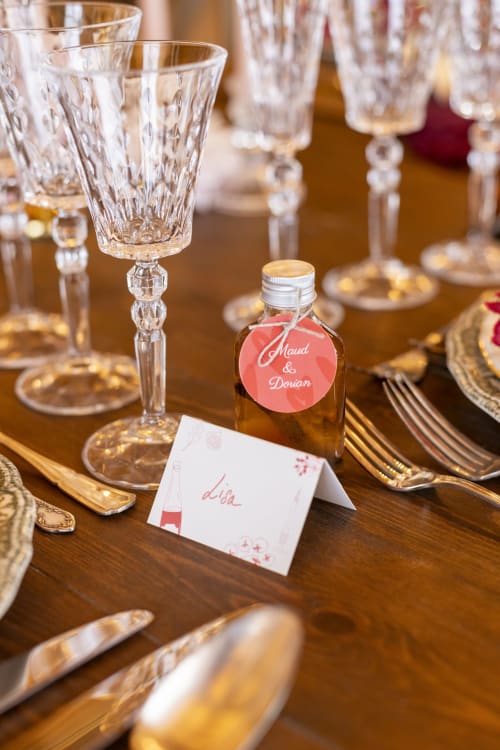 Elegant wedding table setting at Domaine du Tertre Ychot with crystal glasses, gold cutlery, and personalized favor bottle