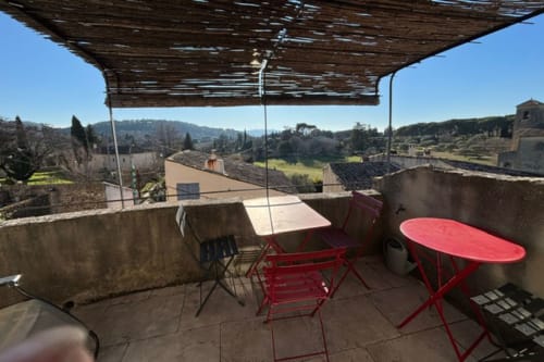 Terrace with red furniture and pergola overlooking Lourmarin castle and Provence mountains, Ancienne Maison des Gardes B&B