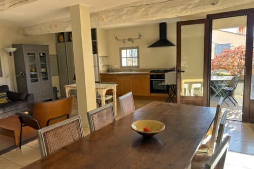 Modern kitchen and dining area in Lourmarin apartment with terrace view of Chateau and autumn foliage
