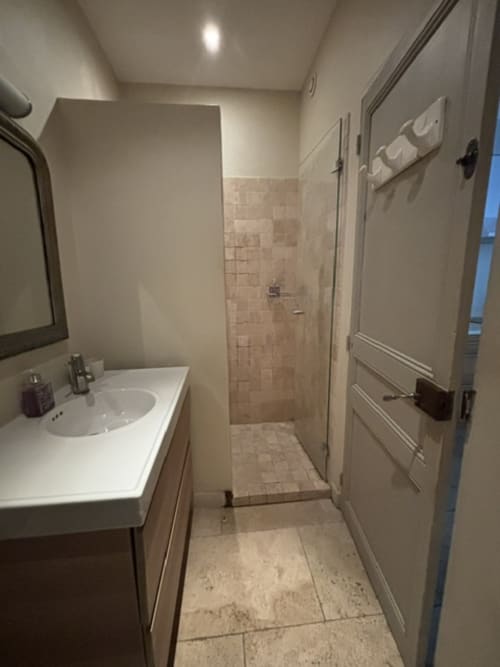 Modern bathroom with white sink, mirror, and walk-in shower in The Music Room apartment at Ancienne Maison des Gardes,