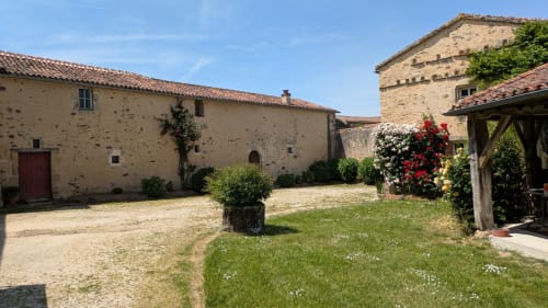 Cours d'entrée avec le Dortoir, l'entrée de l'ancienne chapelle du Prieuré (porte rouge sang) et à droite l'ancienne écurie