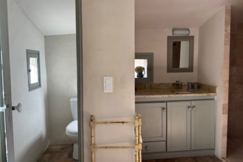 Modern bathroom in Lourmarin village B&B with vanity, mirror, toilet, and tile flooring