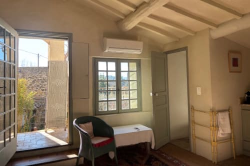Bright balcony room in Lourmarin village with exposed beams, garden view, sitting area, and access to outdoor space