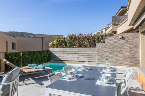 Villa Oia pool terrace at Favone, with dining area, loungers, and heated pool managed by Corsu di Core conciergerie