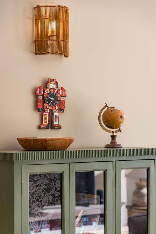 Shelf display in Villa Oia with wooden bowl, toy robot clock, managed by Corsu di Core conciergerie