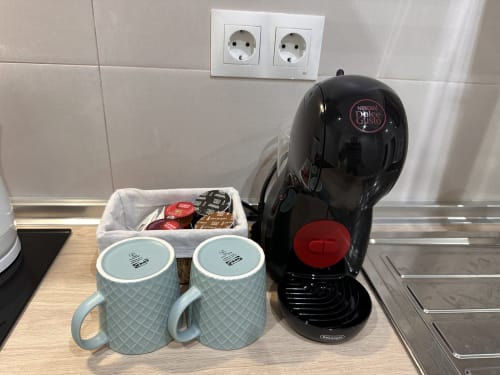 Cafetera Nespresso Dolce Gusto con tazas y cápsulas en la cocina del apartamento de Nerja Holiday Homes