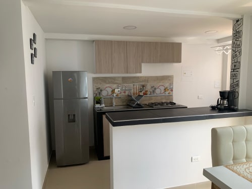 Cocina moderna en apartamento Lake View Coveñas de Olamar Living, Santiago de Tolú con electrodomésticos de acero inoxidable y negro