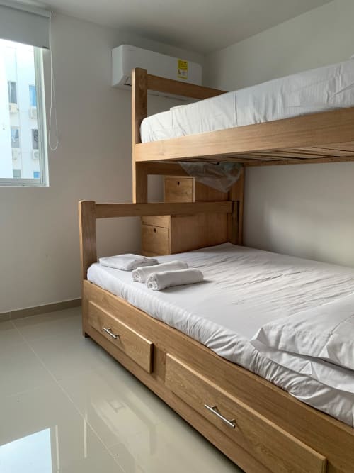 Camas literas de madera con ropa de cama blanca en el apartamento Lake View Coveñas del hotel Olamar Living, Tolú, Sucre