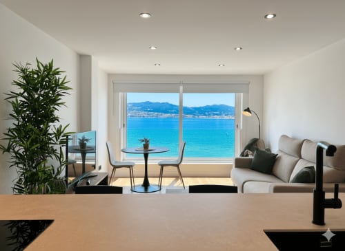 Elegante apartamento en Baiona con vistas panorámicas al mar, sofá moderno, mesa de comedor y costa 