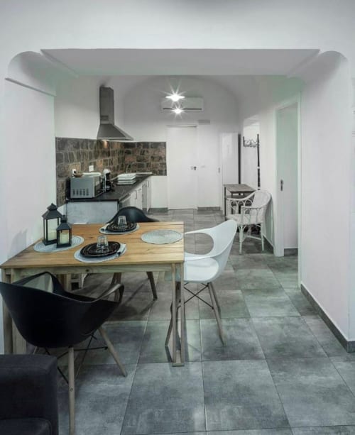 Cocina y comedor modernos en Mérida con mesa de madera, sillas blancas, salpicadero oscuro y diseño contemporáneo