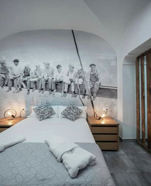 Dormitorio moderno en apartamento Gestyp-AT en Mérida con mural vintage sobre la cama y mesitas de noche de madera