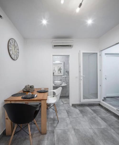 Apartamento moderno en Mérida con comedor, mesa de madera, sillas contemporáneas y vista al baño