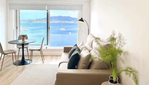Apartamento Meiga do Mar en Baiona con vista al mar, sofá moderno, comedor y montañas visibles a través de amplios ventanales