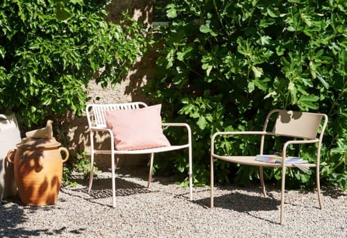 Gezellig zithoek bij Moulin Renaudiots in Autun met twee stoelen, roze kussen en terracotta pot omgeven door groen