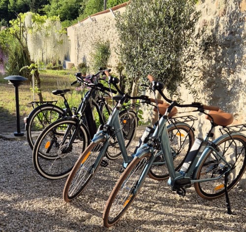 Elektrische fietsen geparkeerd bij Hotel Moulin Renaudiots in Autun, Frankrijk, beschikbaar voor gasten ter verhuur