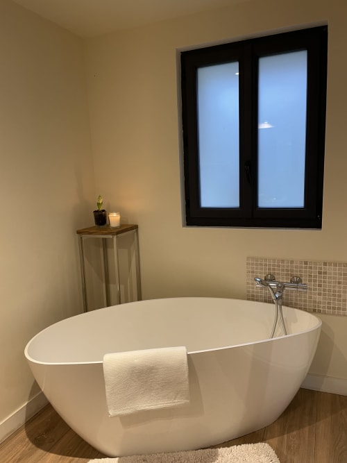 Modern freestanding bathtub with towel in luxury bathroom at Clairseine cottage, Tournedos-sur-Seine