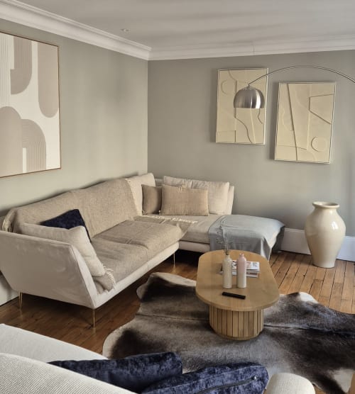 Modern zitgedeelte in Moulin Renaudiots met beige bank, houten salontafel en uitzicht op Autun