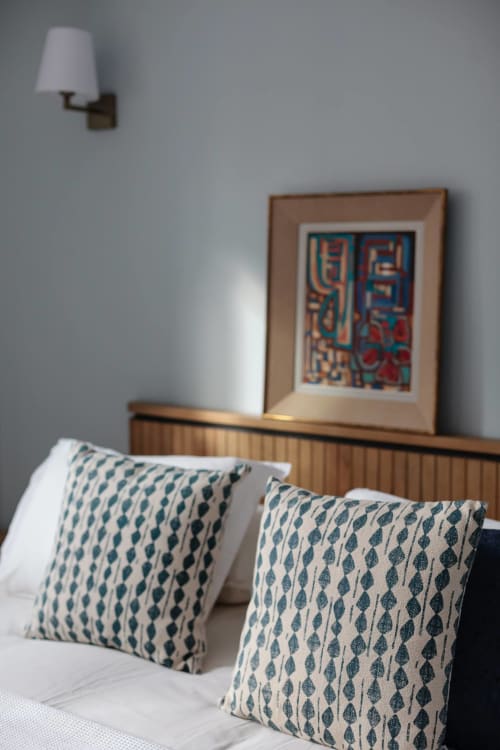 Moderne slaapkamer in Moulin Renaudiots met patterned kussens, houten bedframe, ingelijste kunstwerken en wandlamp in Autun