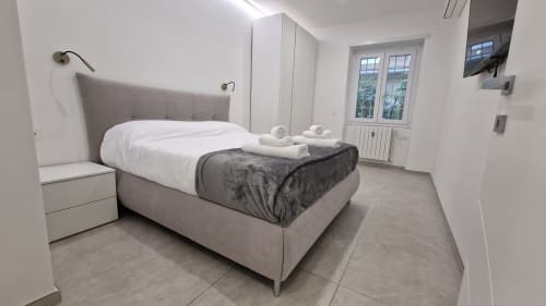 Camera moderna dell'appartamento Zoelia Cipro a Roma con letto imbottito grigio, biancheria bianca e vista sulla città