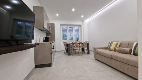 Moderno appartamento Cipro a Roma con living open-plan, cucina, zona pranzo e divano beige