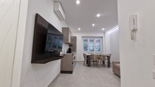 Cucina e sala da pranzo open-plan moderna dell'hotel Zoelia di Roma con TV a parete, arredi contemporanei e grande