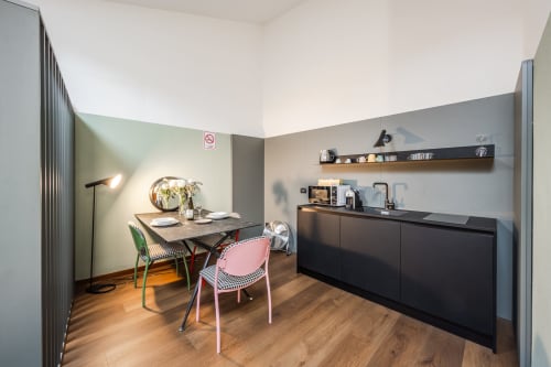 Moderno appartamento presso Le Arche Verona con zona pranzo, angolo cottura, area di lavoro e arredamento contemporaneo su pavimentazione in legno