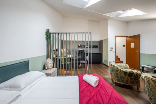 Moderno monolocale presso Le Arche Verona con letto, zona living, cucina a vista dietro divisorio, vista sulla città, pavimenti in legno