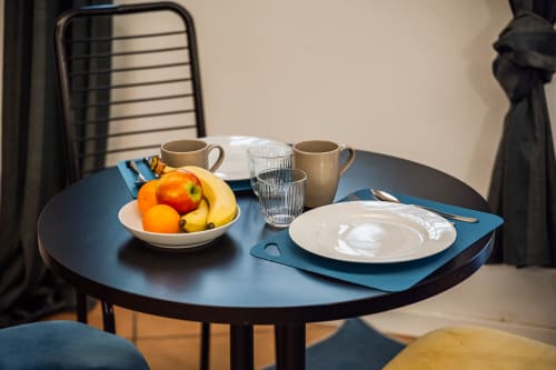 Tavolo da pranzo dell'appartamento Le Arche a Verona con mise en place, frutta fresca e bevande