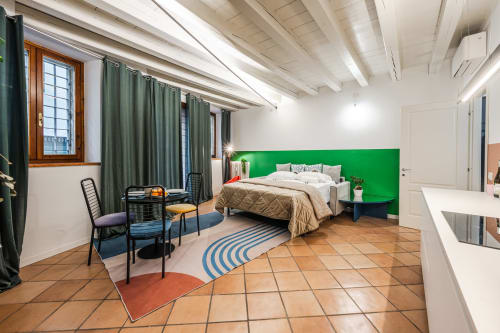 Appartamento Flumen a Verona con testata letto verde vivace, pavimenti in cotto e servizi moderni inclusa zona pranzo