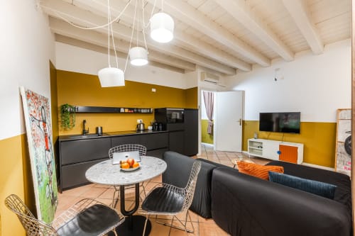 Moderno appartamento Le Arche a Verona con pareti gialle, cucina aperta, arredamento nero e vista sulla città