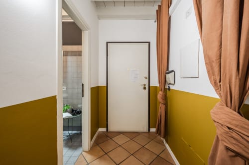Ingresso moderno dell'hotel Le Arche a Verona con pareti gialle e pavimento in cotto