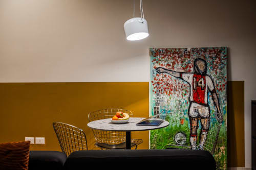 Zona pranzo in moderno appartamento con tavolo in marmo, sedie in metallo e street art contemporanea a Verona
