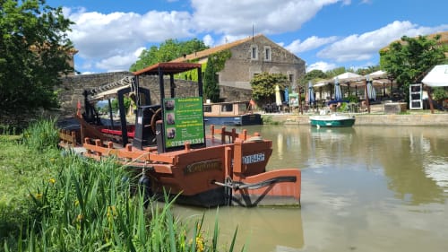 Péniche rouge sur le Canal du Midi au somail pour une promenade rafraichissante ou aller au restaurant près de la chambre d’hôte   Le N°9 à Argeliers, France avec architecture rurale