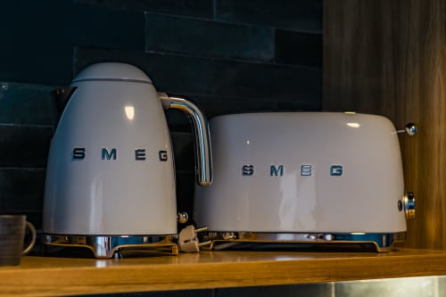 Hervidor y tostador SMEG blancos con detalles cromados en la cocina de un hotel en Oporto