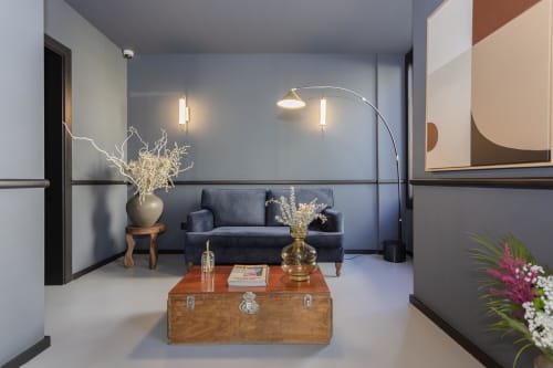 Modern hotel lobby at Benefit Collection Porto with blue sofa, wooden trunk table, and contemporary lighting fixtures
