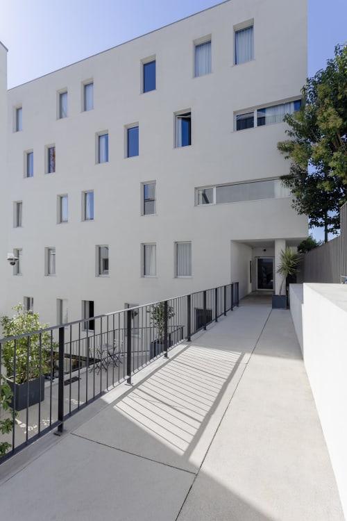 Modern white hotel building in Porto with glass walkway, metal railings, and contemporary architecture