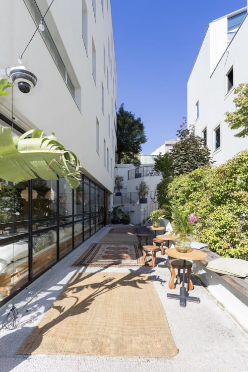 Modern courtyard at Benefit Collection hotel in Porto with white buildings, greenery, and contemporary outdoor seating