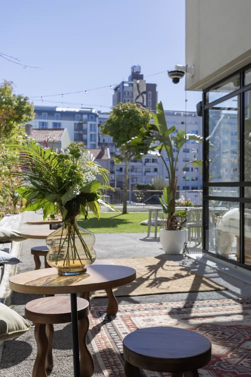 Sunny rooftop terrace at Porto hotel with city views, potted flowers, and modern seating